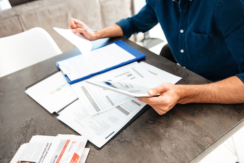 Professionnel contrôlant des documents numérisés sur une tablette